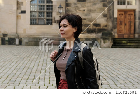 Girl Tourist, With Backpack, Explores Historical Part Of European City, Admiring Landmarks Girl Tourist, With Backpack, Explores Historical Part Of European City, Admiring Landmarks 116826591