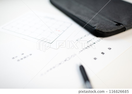 A resignation letter, a schedule book with the resignation date written on it, and stationery placed on a white desk A resignation letter, a schedule book with the resignation date written on it, and stationery placed on a white desk 116826685