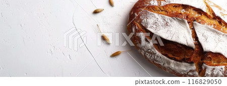 A freshly baked wheat bread loaf sits on a white background. 116829050