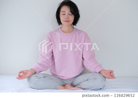 Middle-aged woman meditating to calm her mind 116829652