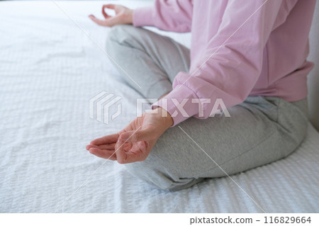 Middle-aged woman meditating to calm her mind 116829664