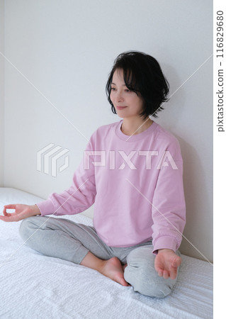 Middle-aged woman meditating to calm her mind 116829680