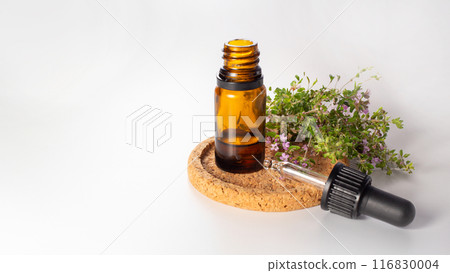 Fresh thyme and essential oil isolated on the white background. Hair treatment concept. Close up. Copy space Fresh thyme and essential oil isolated on the white background. Hair treatment concept. Close up. Copy space 116830004