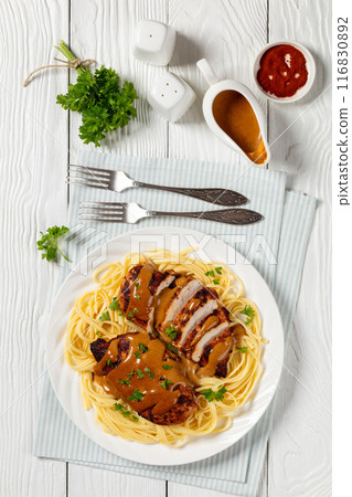 Chicken Lazone with sauce and linguine on plate Chicken Lazone with sauce and linguine on plate 116830892