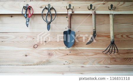 gardening tools hanging on a wooden wall 116831318