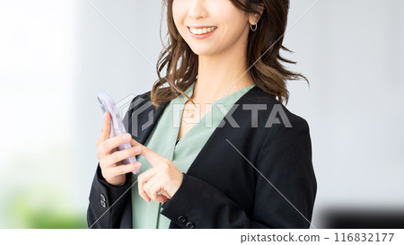 Smiling Japanese business woman holding a smartphone Smiling Japanese business woman holding a smartphone 116832177