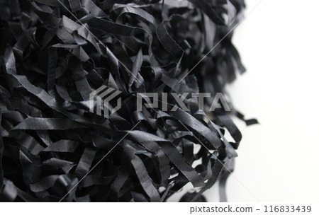 Intertwined strips of crumpled black wrapping paper isolated on white. Paper shavings for decoration stock photo 116833439