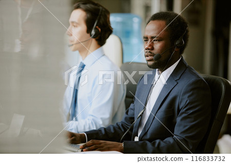 Two biracial workers of contact center having clients call during long work day 116833732