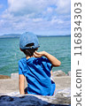 Boy throwing stones into the sea 116834303