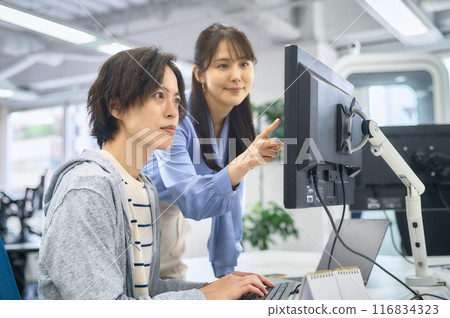 Male and female engineers in plain clothes working in the office 116834323