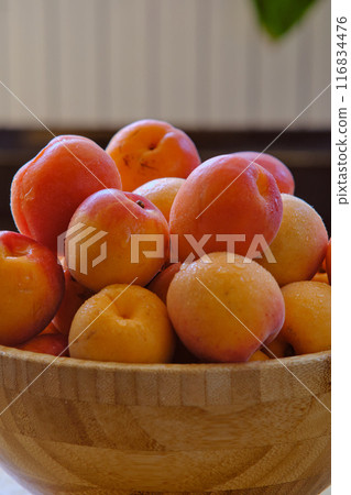 a group of ripe apricots on a wooden plate 116834476