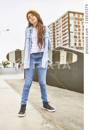 Girl having fun riding skateboards at skate park, Portrait of smiling young female skateboarder holding her skateboard. Recreational Activity Concept. Girl having fun riding skateboards at skate park, Portrait of smiling young female skateboarder holding her skateboard. Recreational Activity Concept. 116835374