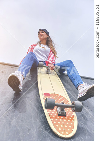 Beautiful and fashion woman posing with a skateboard Young woman is posing with skateboard in the city, female teenager outdoor with long board. Beautiful and fashion woman posing with a skateboard Young woman is posing with skateboard in the city, female teenager outdoor with long board. 116835551