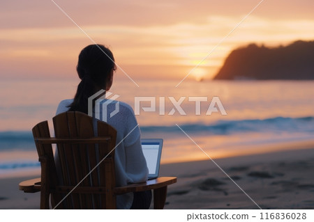 Woman Working on Laptop at Sunset Beach 116836028