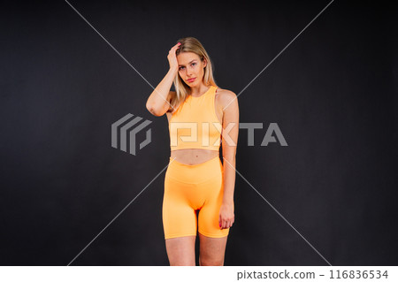 Portrait, fitness or body of young woman in studio isolated on a yellow black red background. Portrait, fitness or body of young woman in studio isolated on a yellow black red background. 116836534