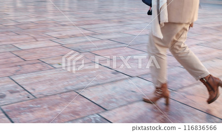 Rush people. Blurred motion of person in mid-stride on a tiled floor, showcasing lower half clad in light trousers and brown shoes Rush people. Blurred motion of person in mid-stride on a tiled floor, showcasing lower half clad in light trousers and brown shoes 116836566