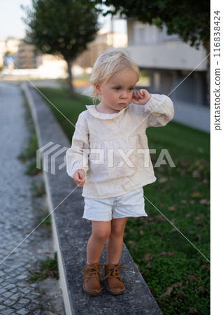 Beautiful little girl walking outdoor feeling alone and sad Beautiful little girl walking outdoor feeling alone and sad 116838424