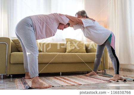 Senior woman exercising at home together with daughter. Senior woman exercising at home together with daughter. 116838766