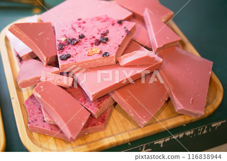 Wooden tray with magenta chocolate on a table at the event 116838944
