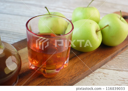 apple vinegar in glass bottle with fresh green apple on table  116839033