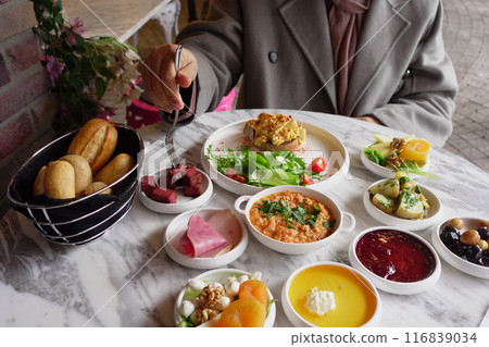 woman is enjoying turkish breakfast at cafe  116839034