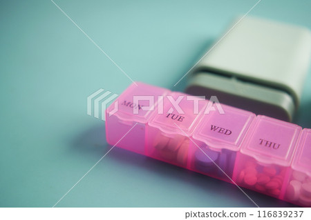 close up of medical pills in a pill box on table close up of medical pills in a pill box on table 116839237