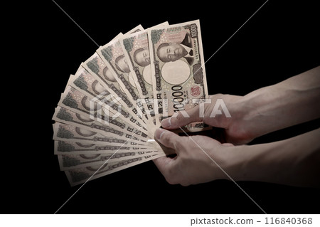 新的日本紙幣。手握 10 張 10,000 日圓鈔票的負像 新的日本紙幣。手握 10 張 10,000 日圓鈔票的負像 116840368