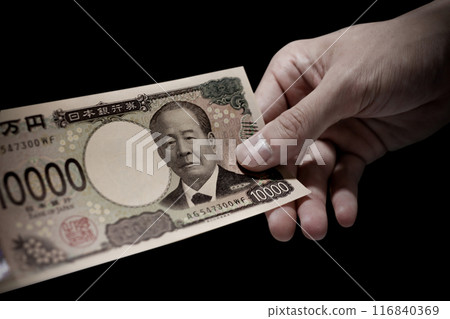 Japan's new banknotes. Negative image of a hand holding a 10,000 yen bill 116840369
