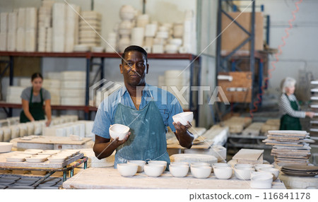 Man ceramist working in pottery workshop Man ceramist working in pottery workshop 116841178