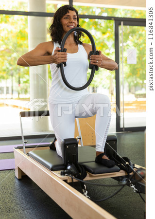 Portrait of active woman practicing with pilates ring 116841306