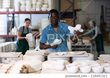African american artisan having ceramics in hands and standing in workshop 116841321