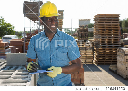 Man worker controlling quantity of bricks at hardware store Man worker controlling quantity of bricks at hardware store 116841350