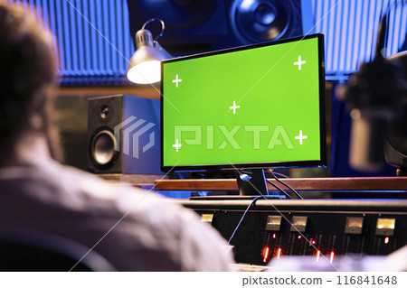 Singer and expert mixing and processing music for a new album in control room at professional recording studio, working on songs. Diverse team of artists producing a new tune. 116841648