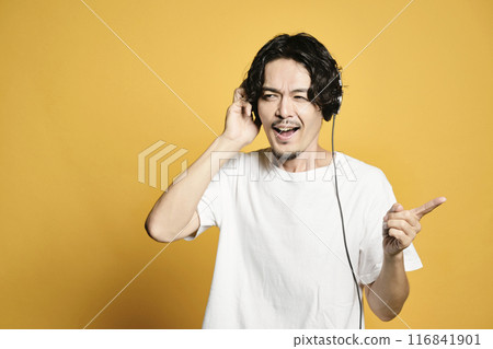 Man listening to music on a color background Man listening to music on a color background 116841901