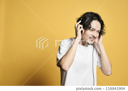 Man listening to music on a color background Man listening to music on a color background 116841904