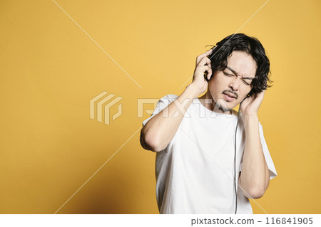 Man listening to music on a color background 116841905