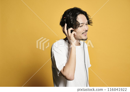 Man listening to music on a color background 116841922