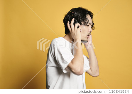 Man listening to music on a color background Man listening to music on a color background 116841924
