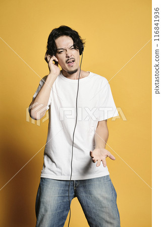 Man listening to music on a color background Man listening to music on a color background 116841936