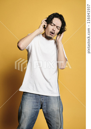 Man listening to music on a color background Man listening to music on a color background 116841937