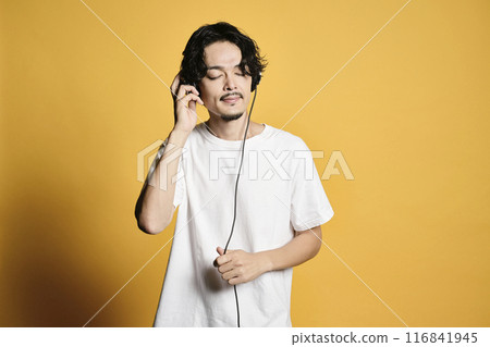 Man listening to music on a color background 116841945