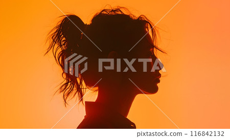 The image showcases the artistic silhouette profile of a woman with a tousled ponytail against a vibrant orange background, creating a bold and emotive artistic expression 116842132