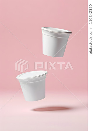 In the photo, two white cups seem to levitate against a pink background, showcasing their elegant packaging and minimalistic design, creating a visually captivating image 116842530