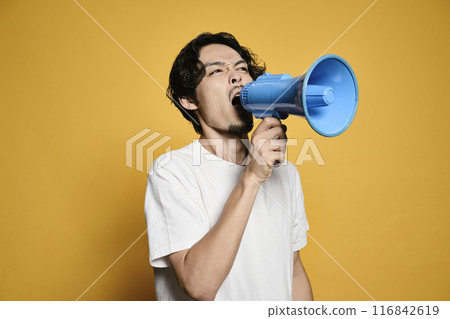 A man shouting into a megaphone against a colored background A man shouting into a megaphone against a colored background 116842619