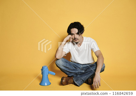 一個男人坐在彩色背景的擴音器上 116842659