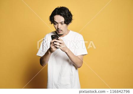 A man touching a smartphone with a colored background A man touching a smartphone with a colored background 116842796