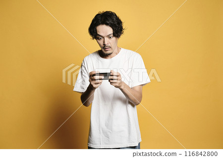 A man touching a smartphone with a colored background A man touching a smartphone with a colored background 116842800