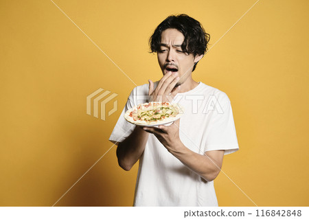 彩色背景的男人吃披薩 彩色背景的男人吃披薩 116842848
