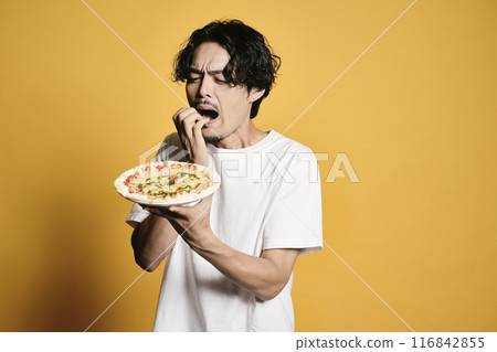 A man eating pizza on a color background 116842855