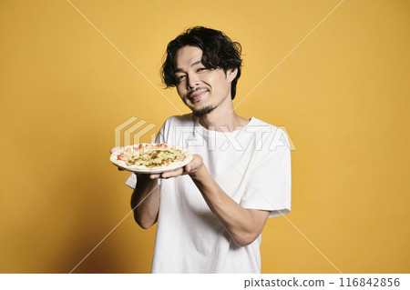 A man eating pizza on a color background A man eating pizza on a color background 116842856